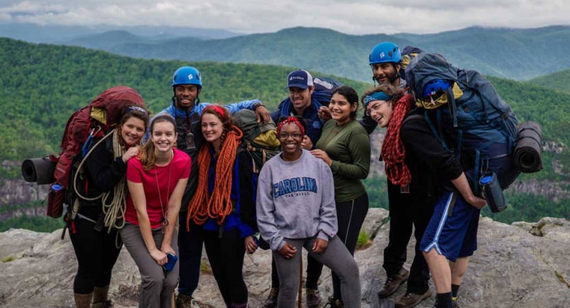 a group of gap year students pause for a photo on an overlook of the blue ridge mountains on an outward bound course